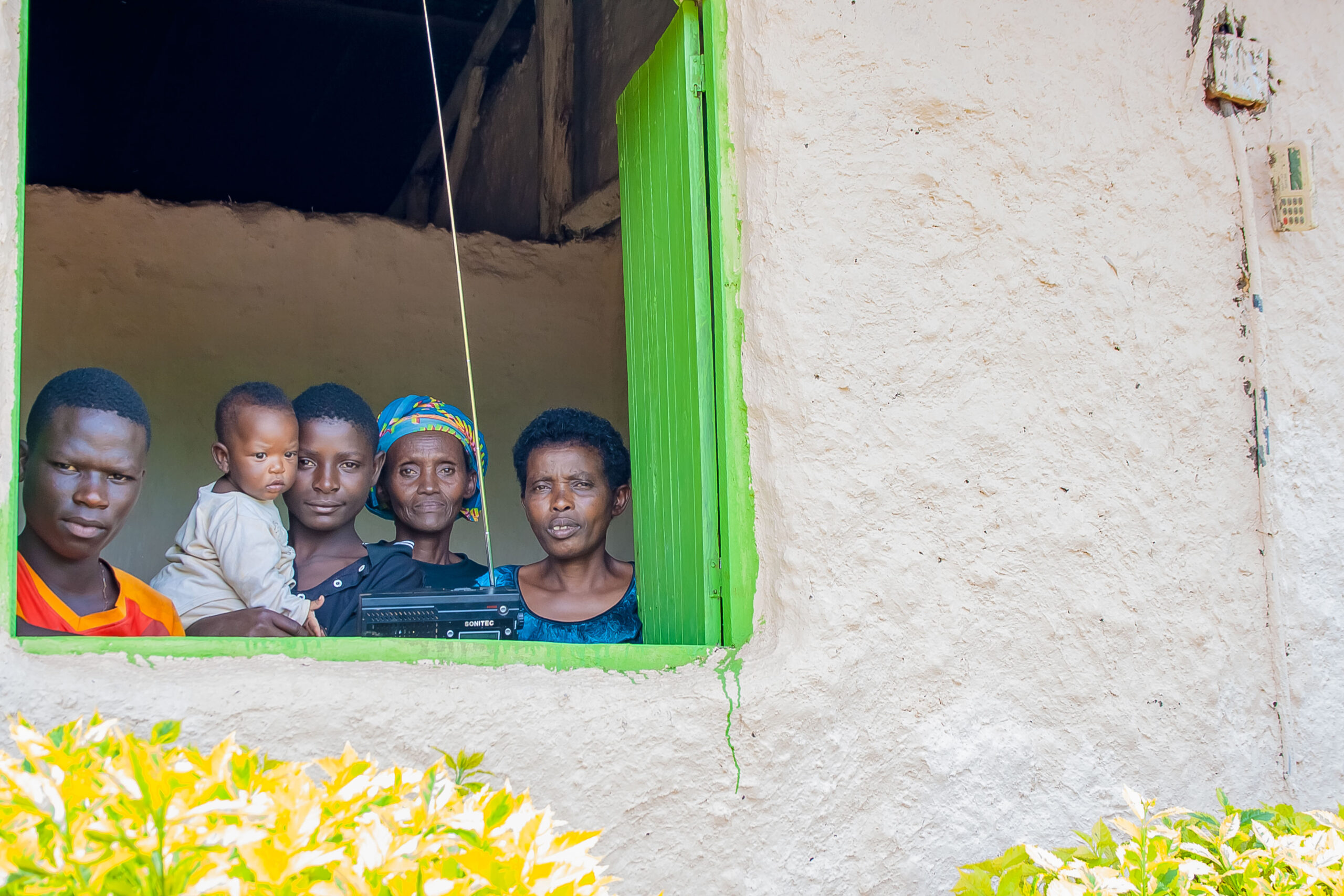 a family standing by the window with a radio