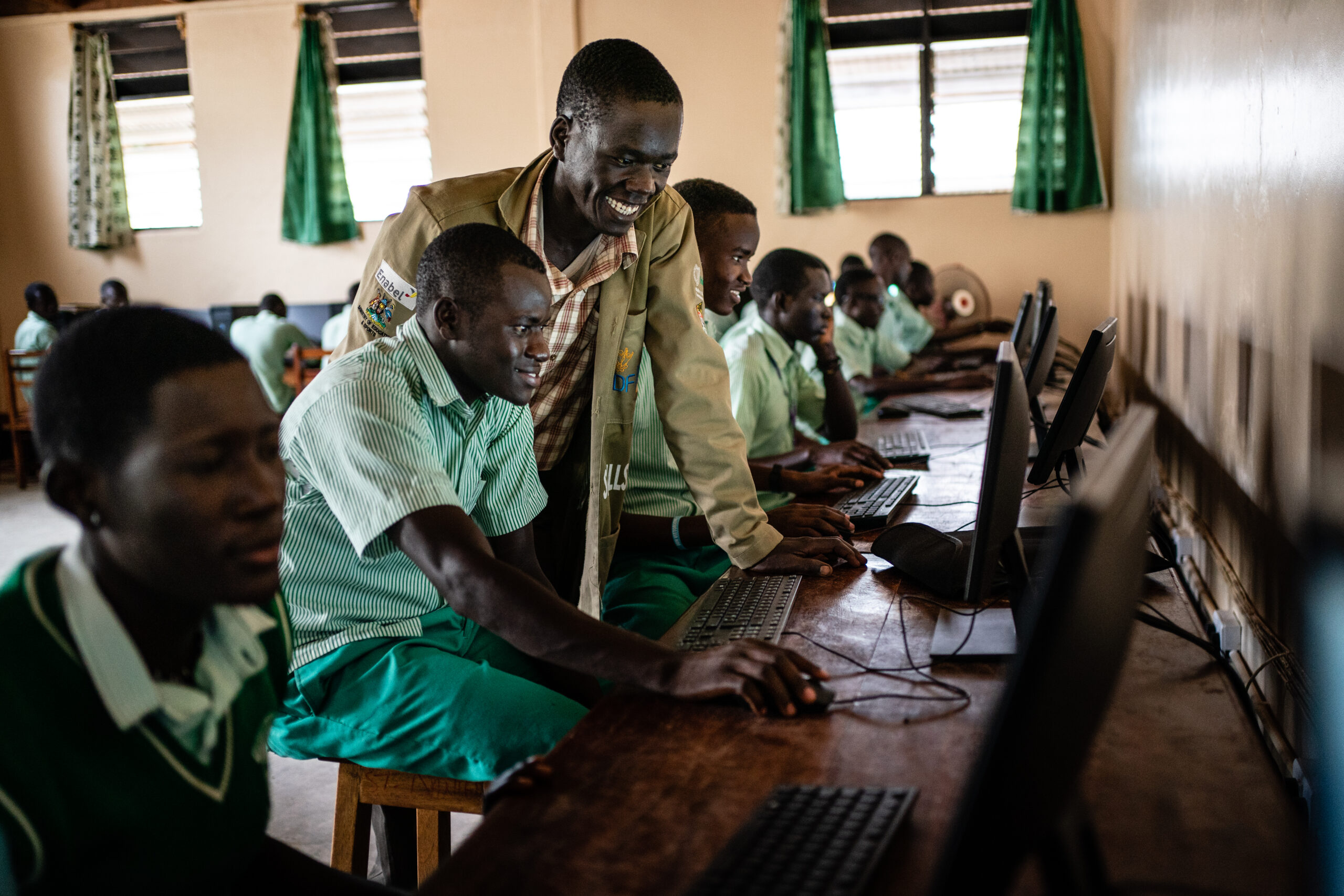 Teacher at a technical vocation institute in Karamoja - Northern Uganda - helps students with their work in the computer lab.