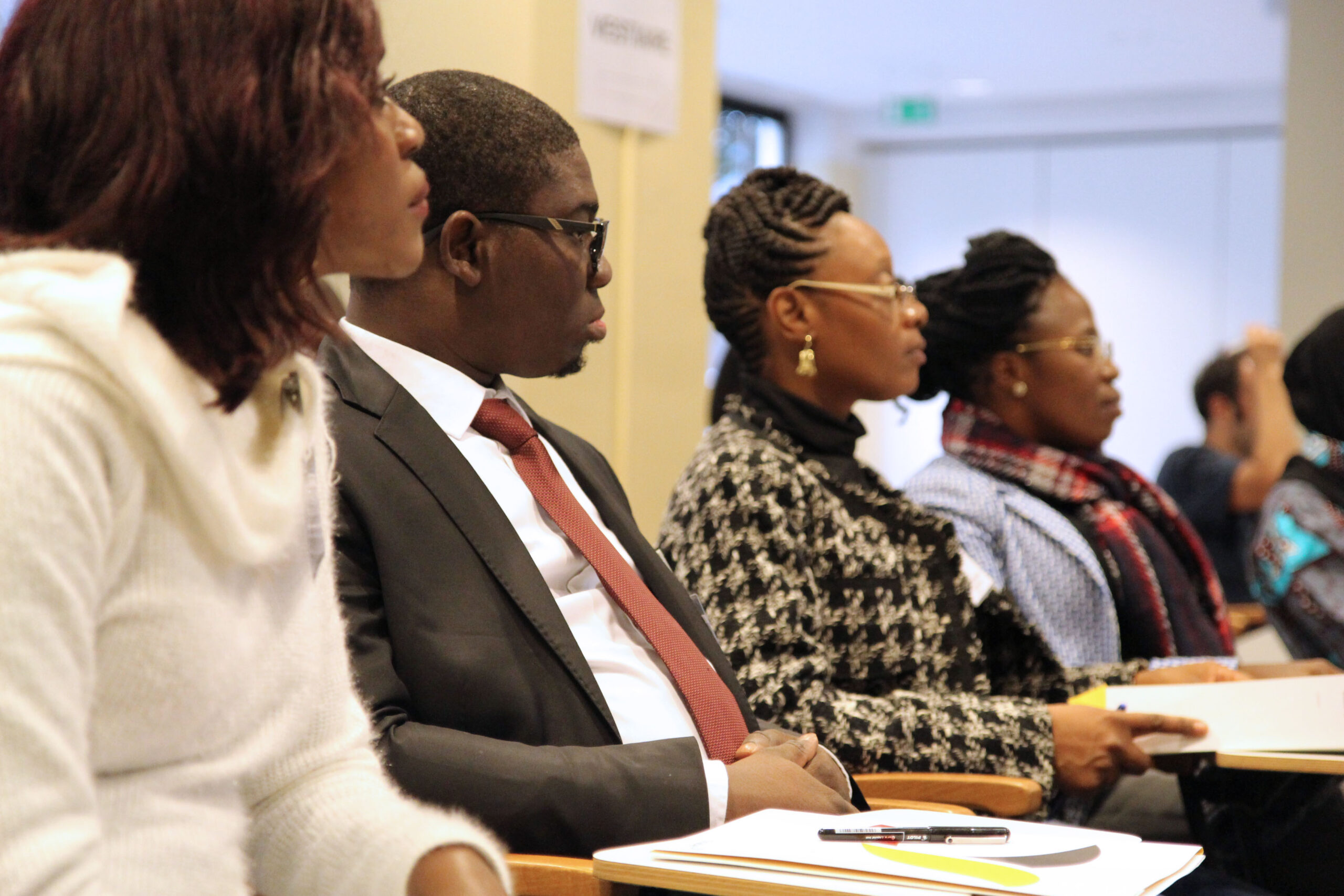 African women and men discussing policies in a board room.