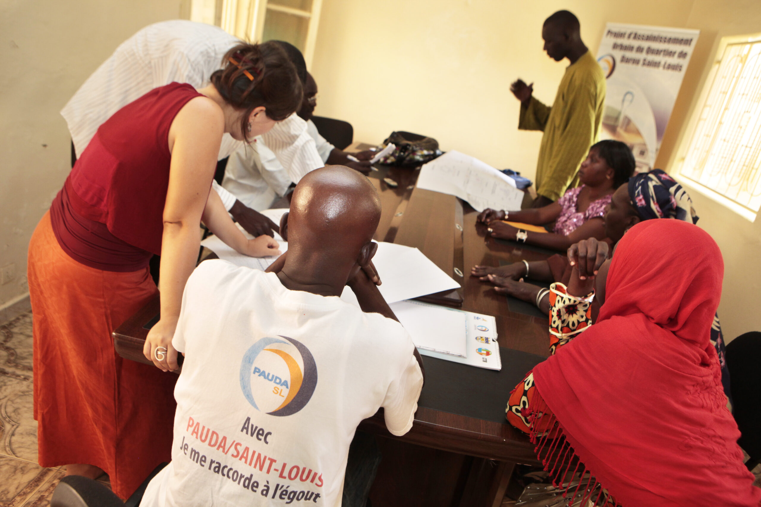 Team in Senegal sitting round a table and working together, discussing ideas.