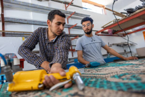 Two young men in Gaza work in their workshop on making windows.