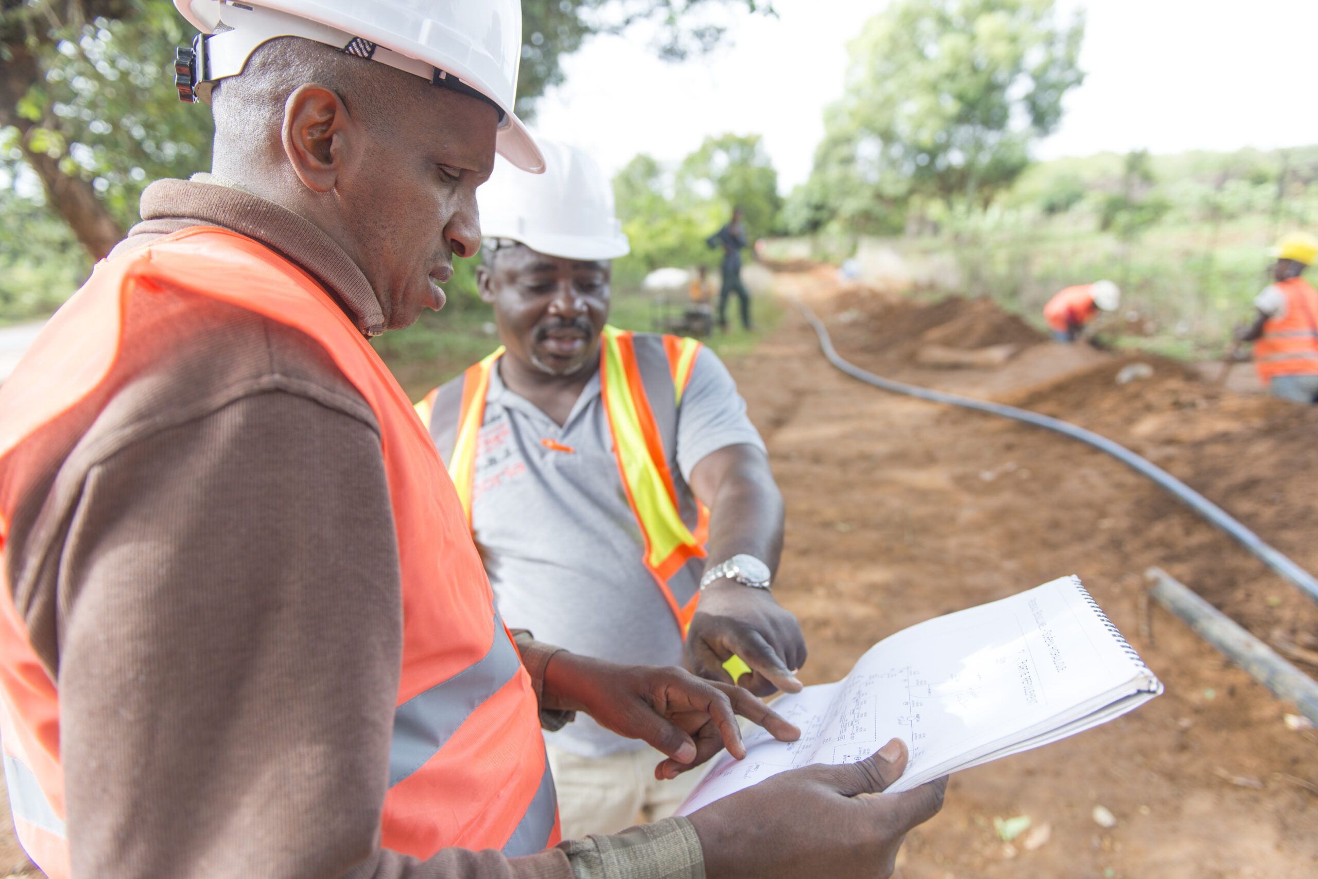 In Guinea contractors have a look at the planning for a water installation they are constructing.