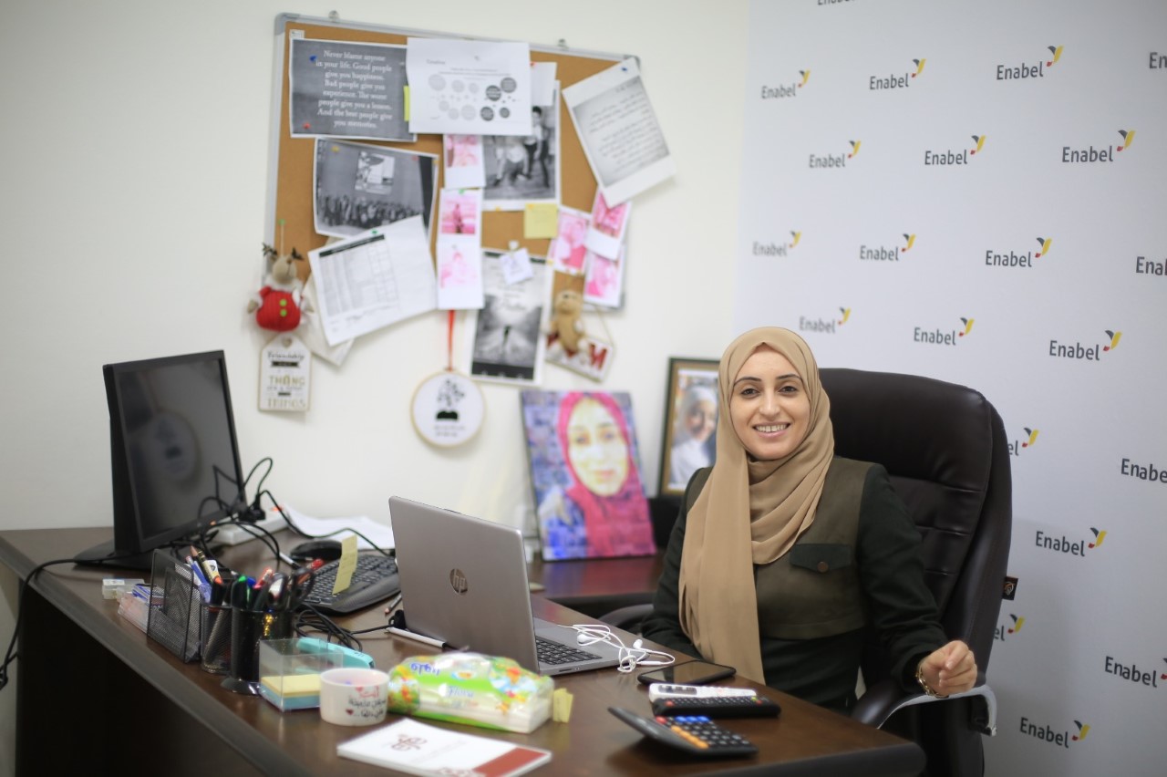 Enabel expert Haneen sit behind her office desk in Gaza, Palestine.