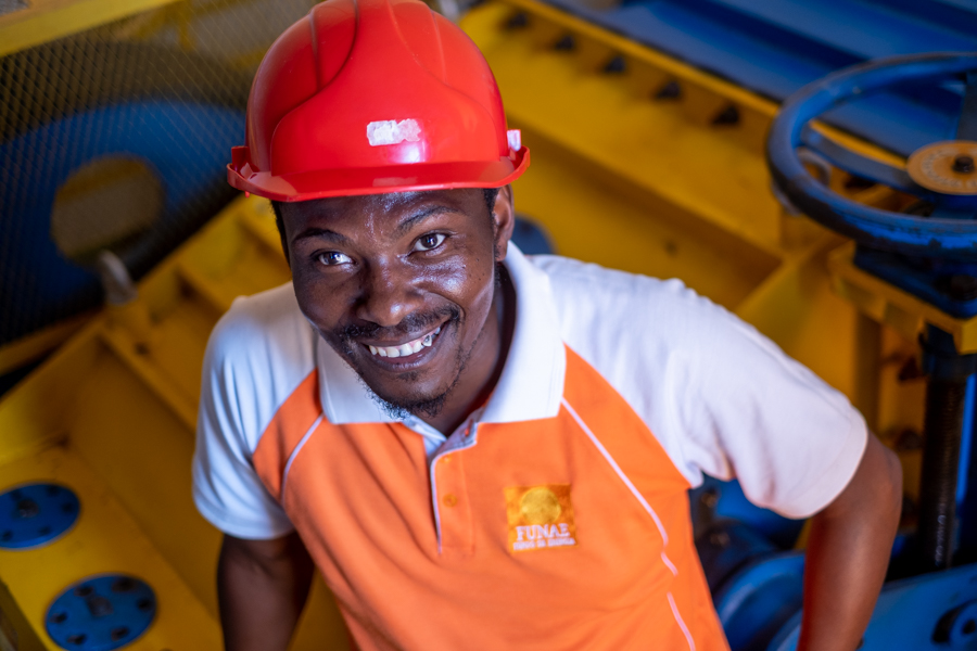 Visit to a small hydro power plant in Mozambique. Man showing people around.