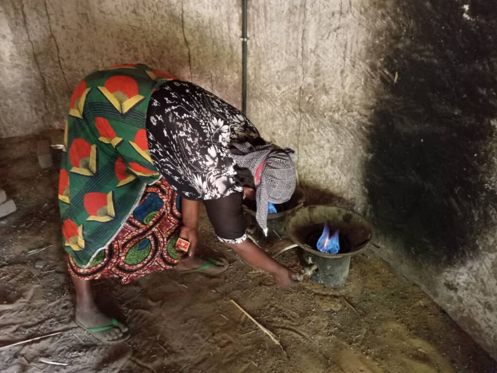 A woman is lighting a stove that works on biogaz in Niger.