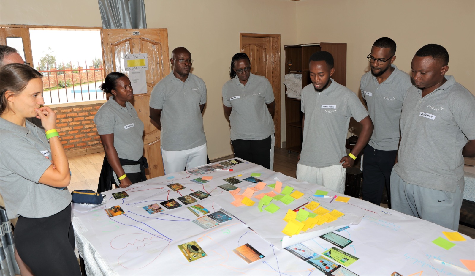 People stand around a table and look at pictures.