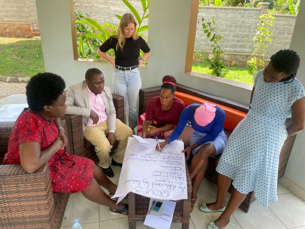 Een groep collega's buigt zich over stuk papier.