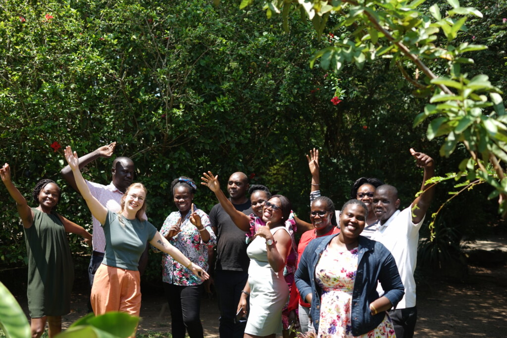 Tiental mensen poseren voor de foto en gooien in hun handen in de lucht.