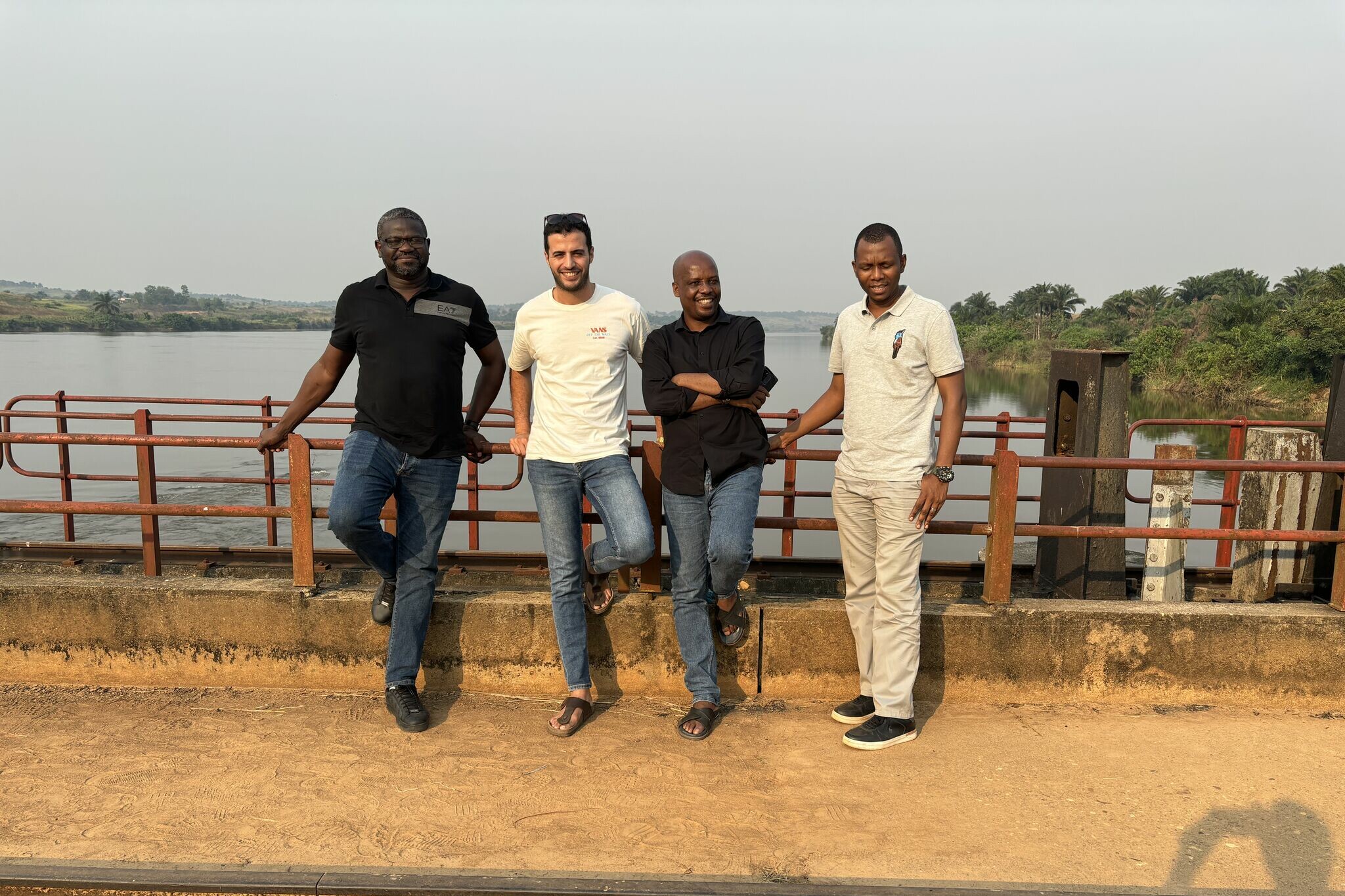 4 men standing next to a bridge