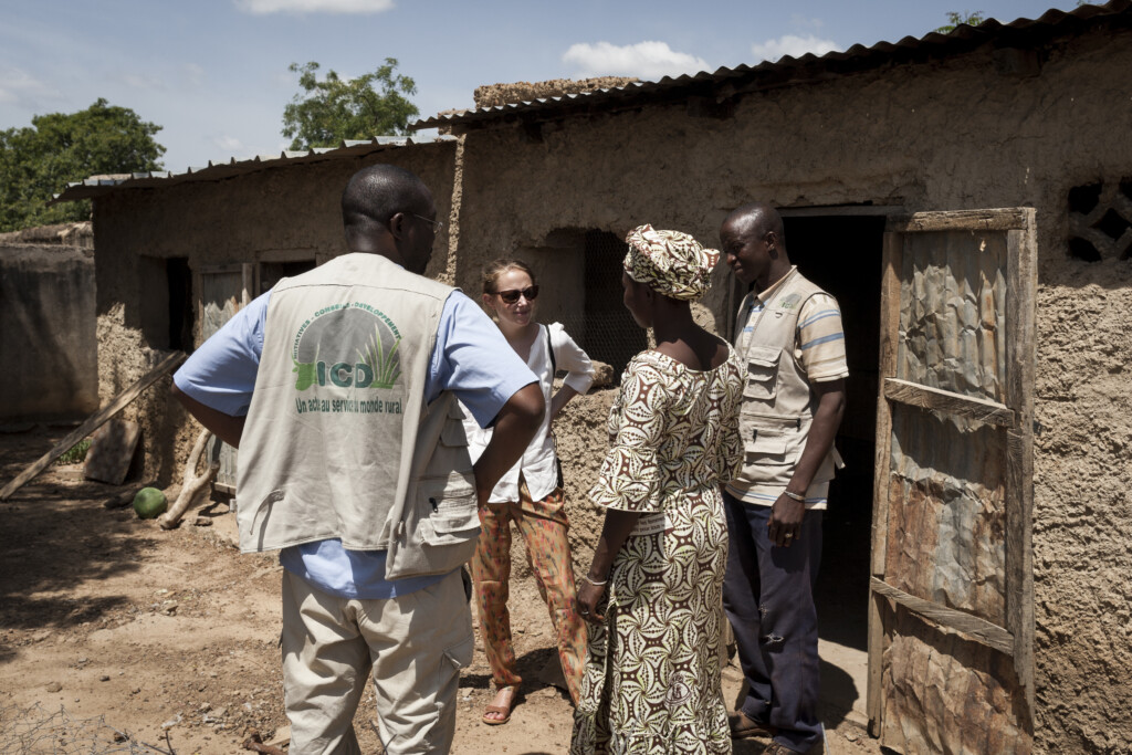 4 people stand in circle and talk.