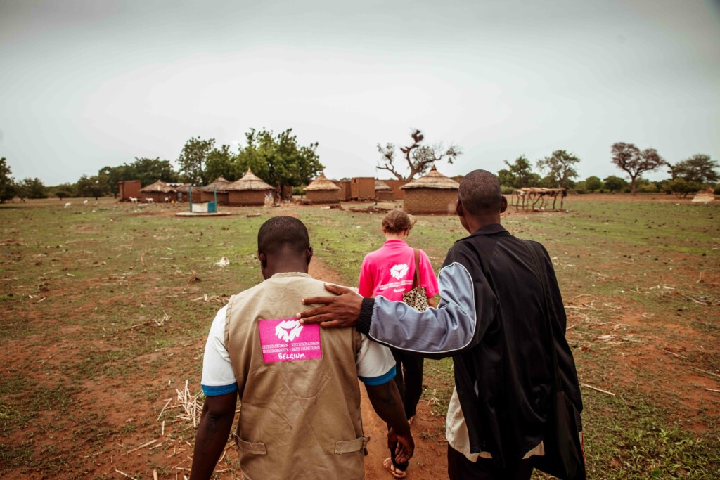 Three people walking with their backs to the viewer.