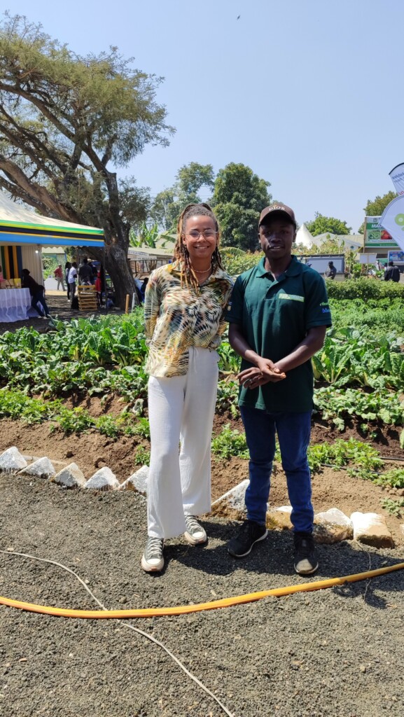 Woman and men pose for a picture in front of a field.