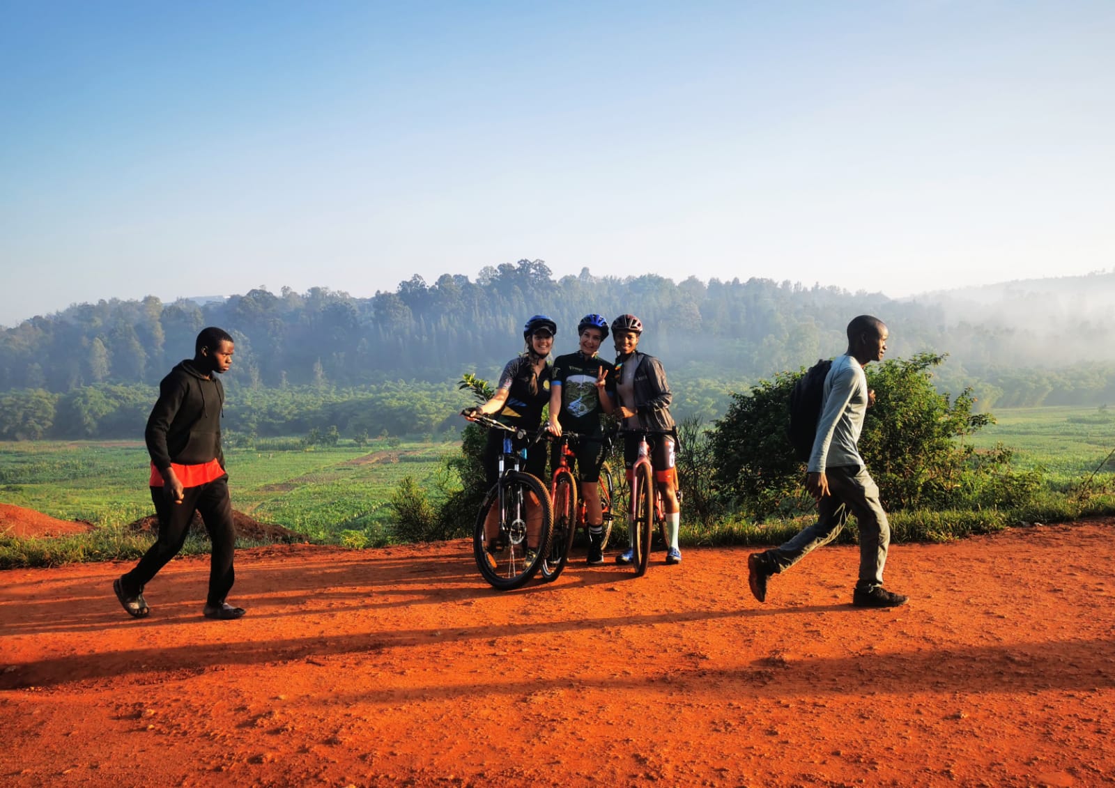3 cyclists by the side of the road.