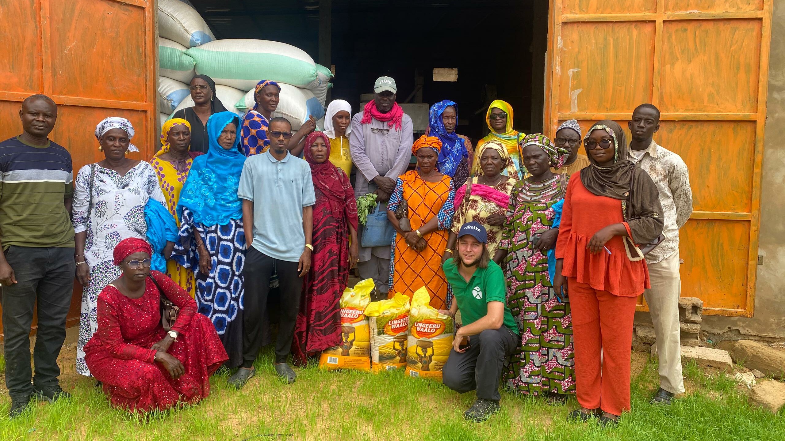 Group of women pose together with partners and show their rice produce.