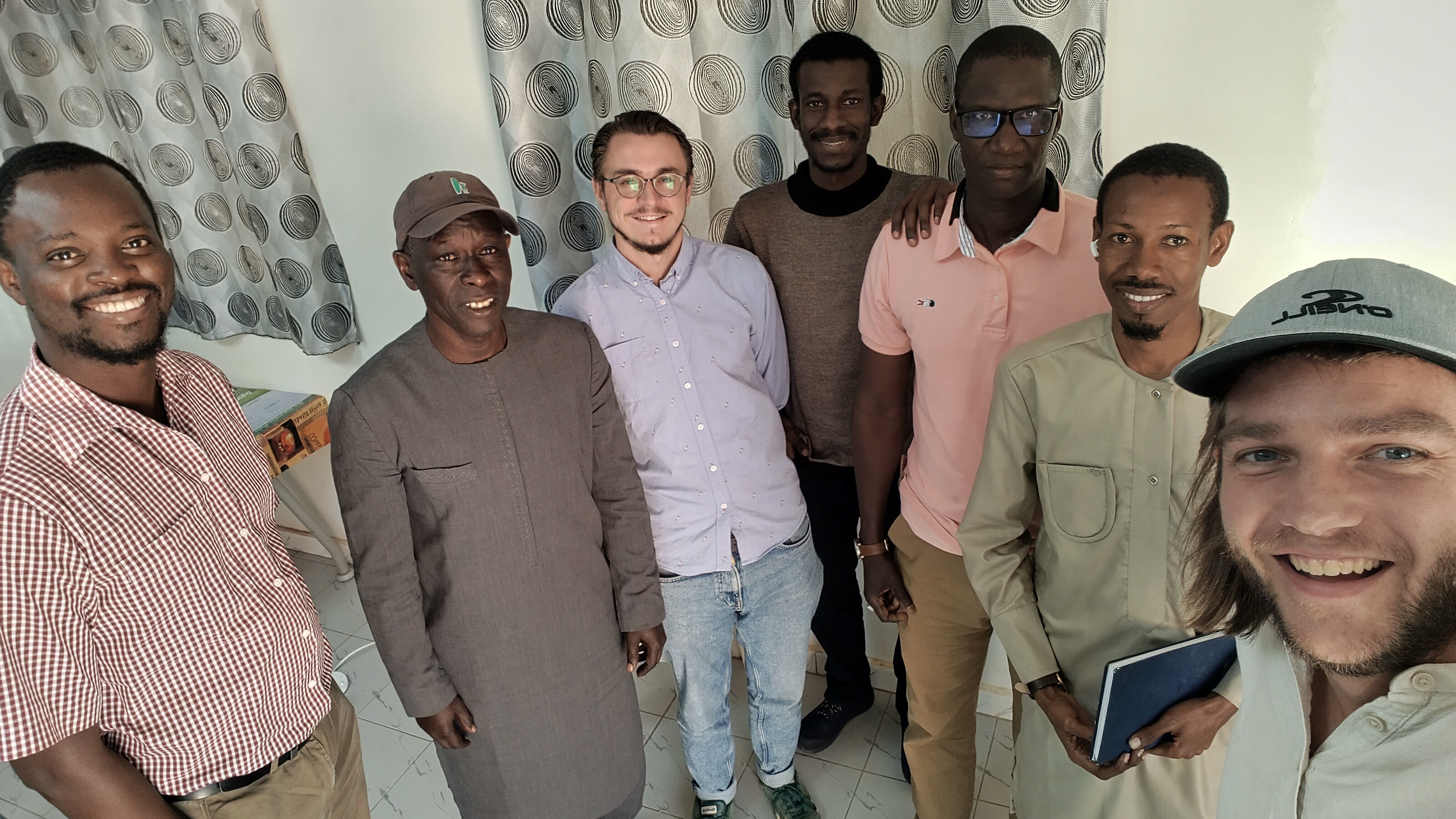 7 colleagues pose for a picture with big smiles.