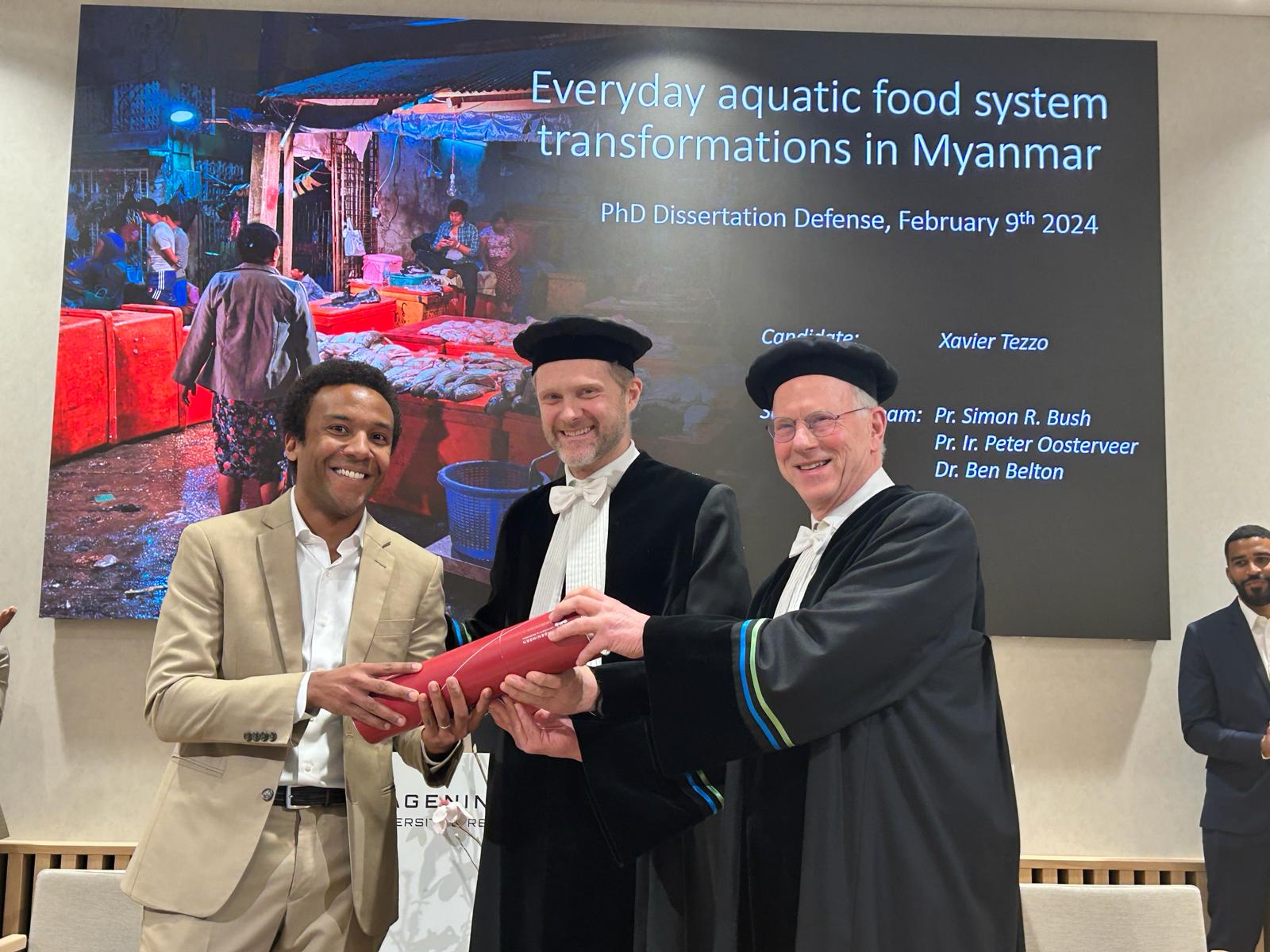 Three man shake hands in a university setting.