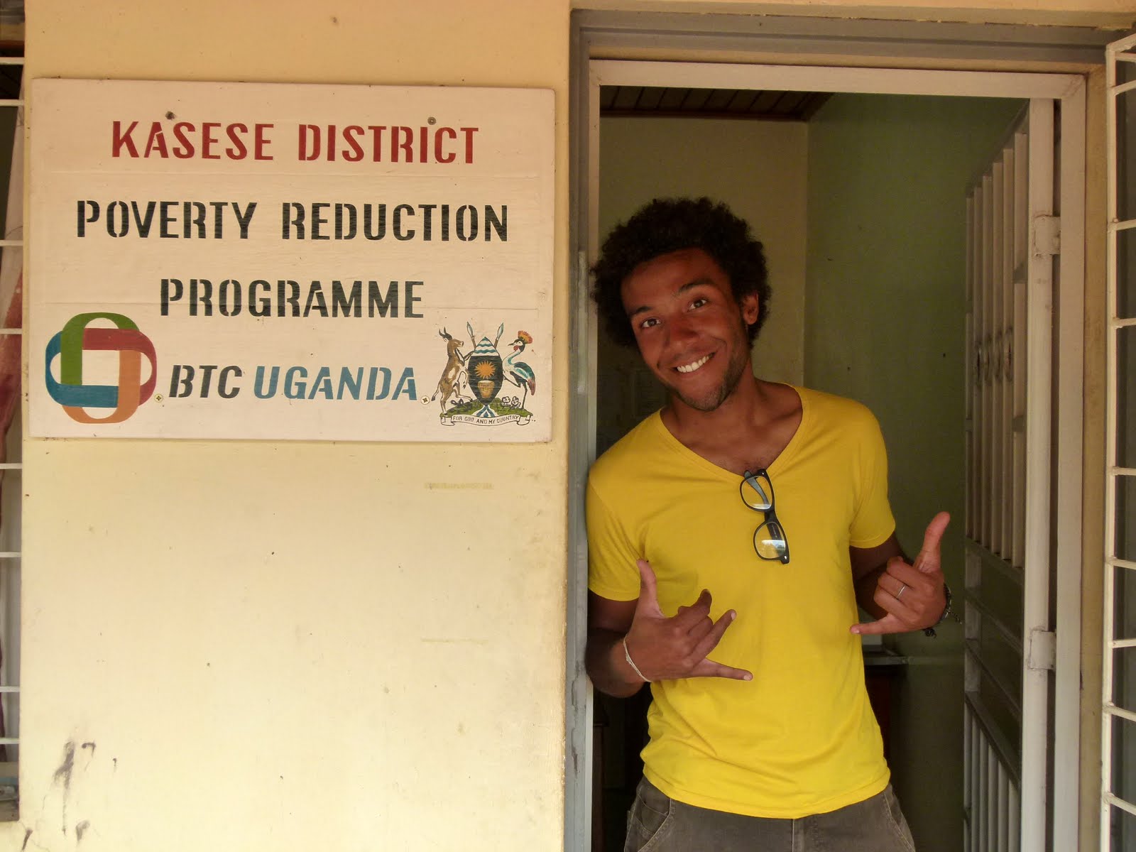 Man stands in a door opening and laughs.