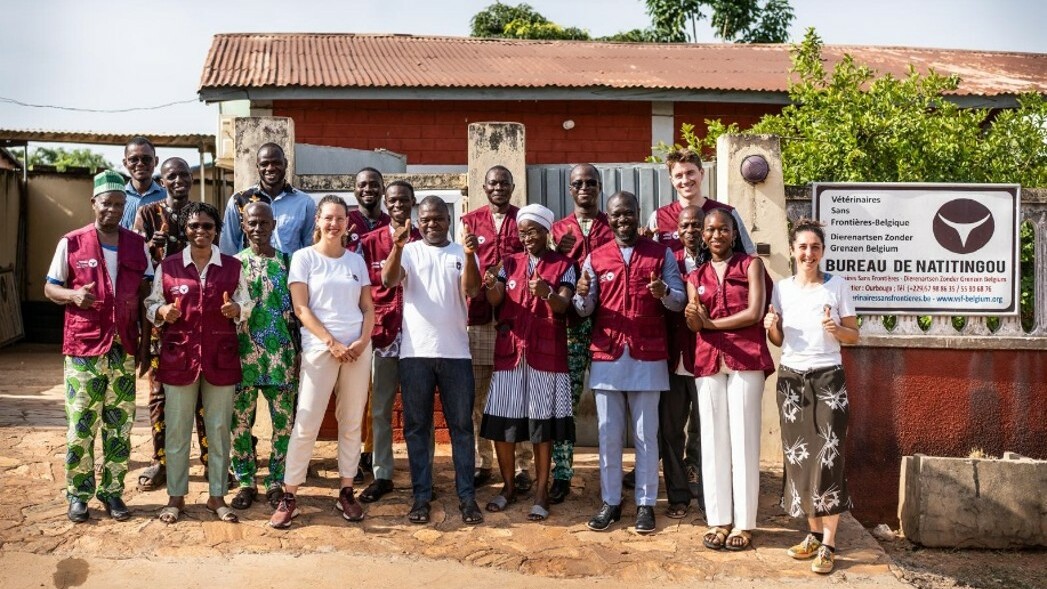 Group of colleagues posing for a picture in front of their office.