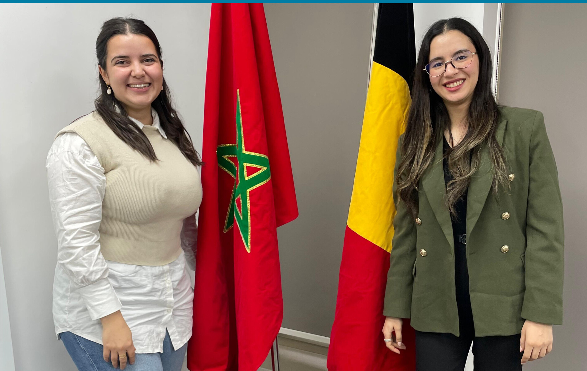 2 young women stands beside the Moroccan and Belgian flag.