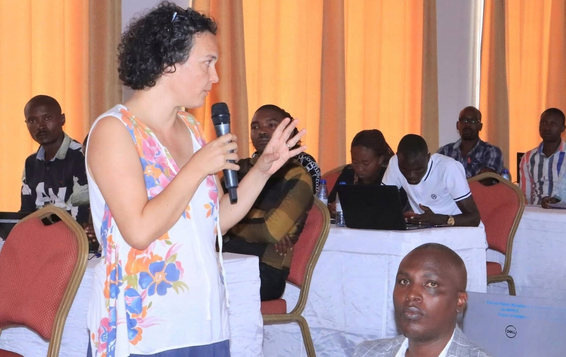 Woman speaking during a conference with microphone in her hand.