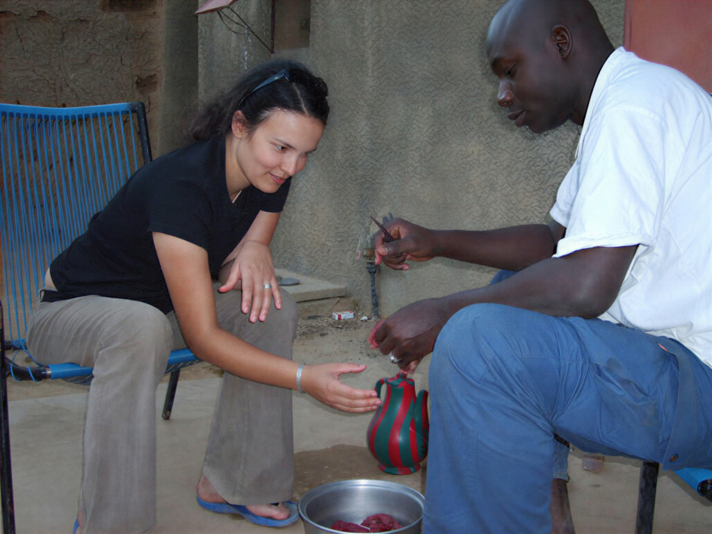 Woman and man cooking together in a courtyard.