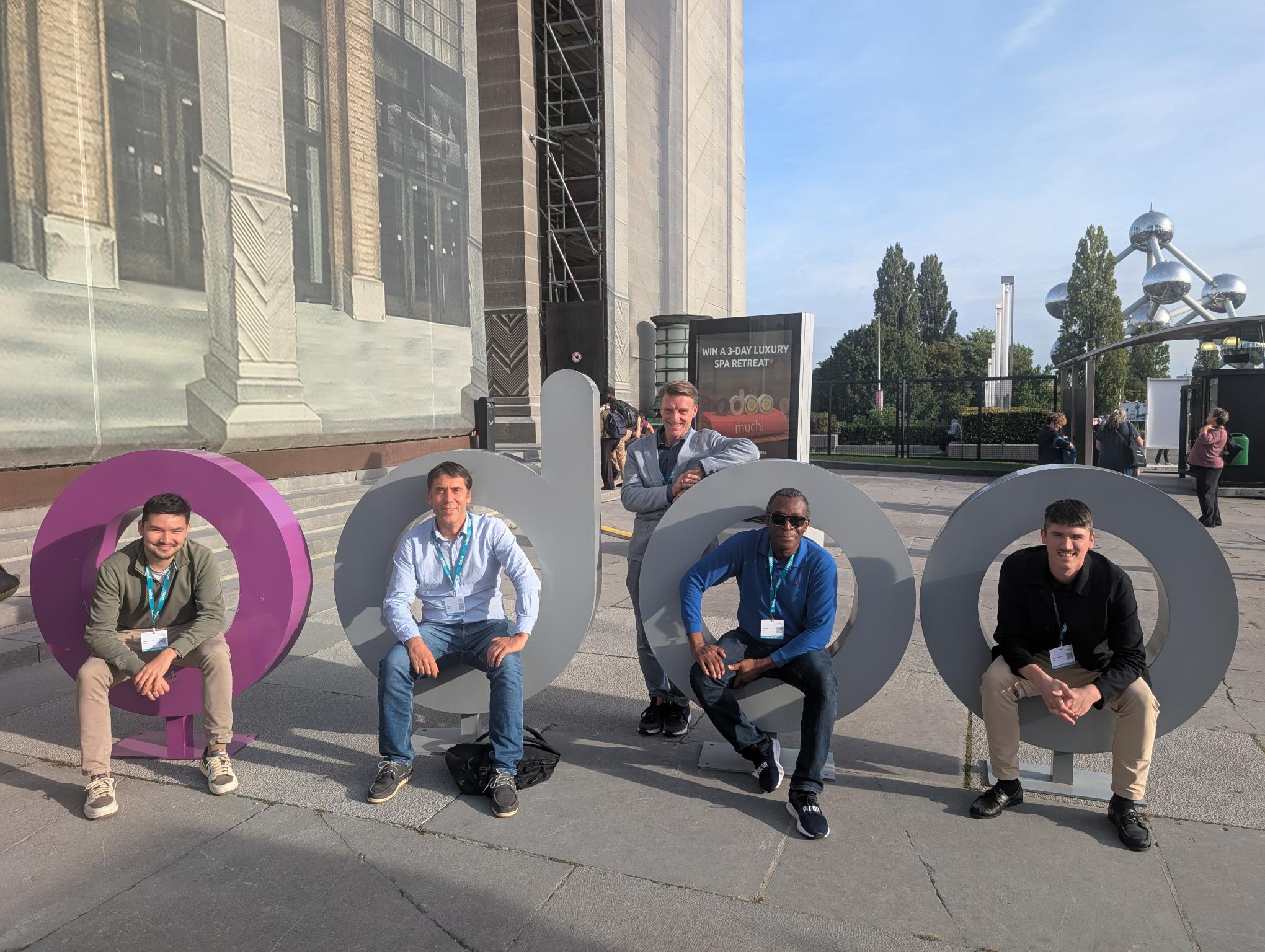 enabel employees posing in front of Odoo logo